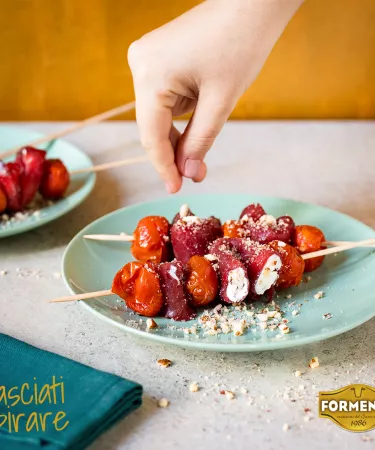 Carpaccio con robiola, pomodorini confit e granella di nocciole